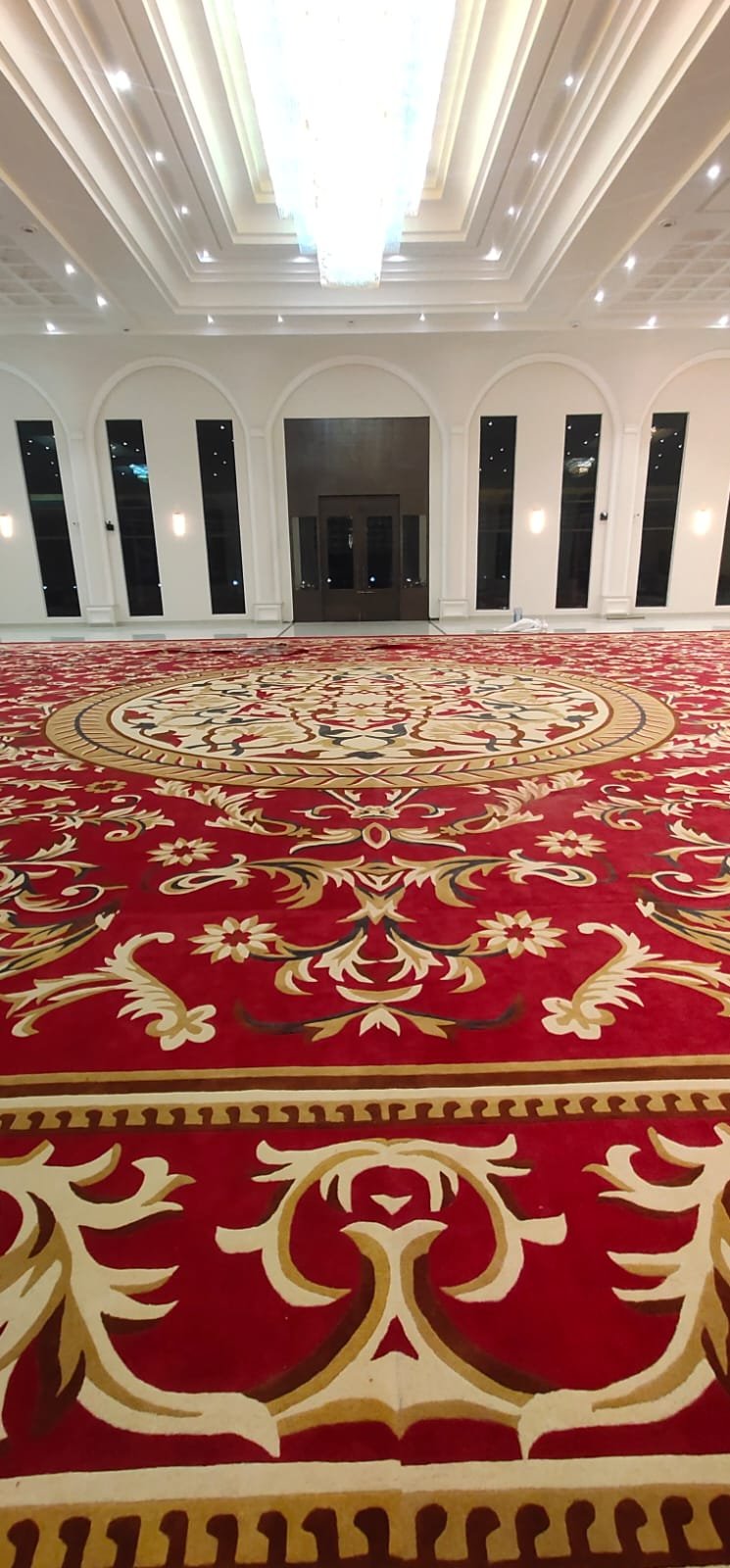 Ballroom floral carpet installation in Vadodara – premium custom red rug for hotels and grand event halls.