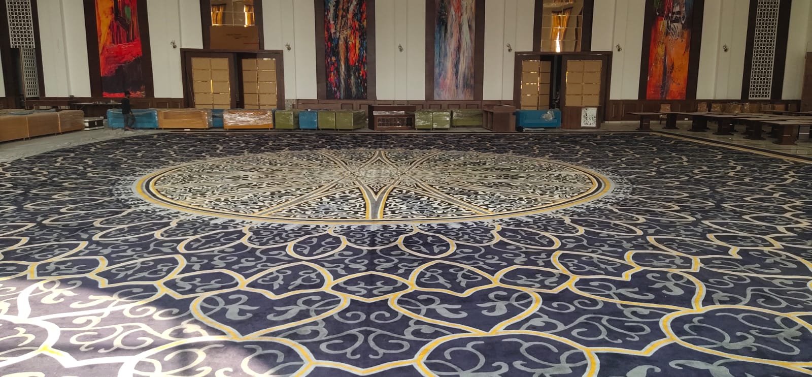 Luxury blue circular pattern carpet installation in Udaipur – custom hand-tufted rug for banquet halls and event venues