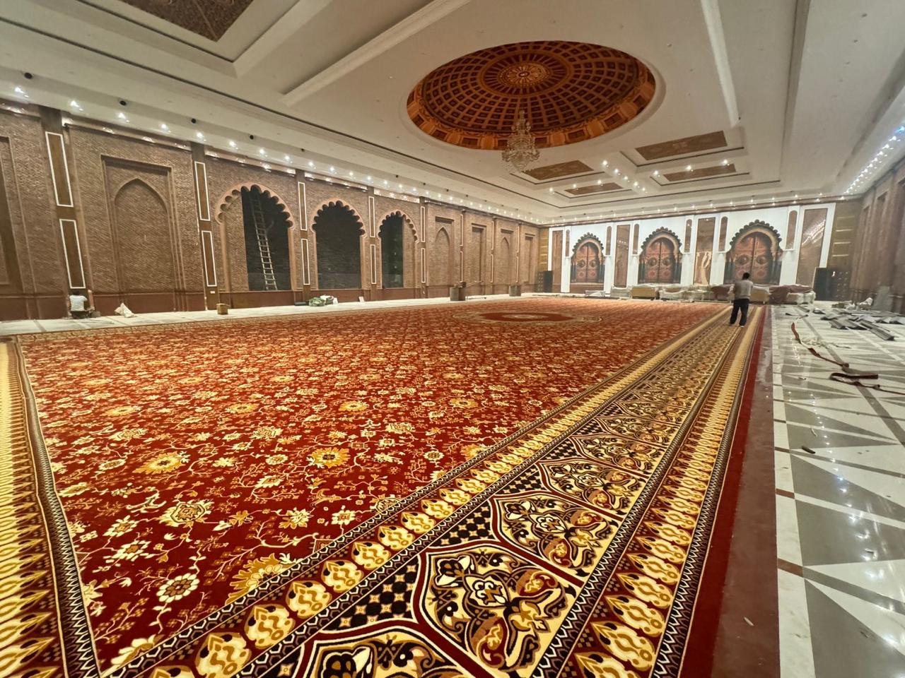 Traditional red carpet flooring for grand halls in Ahmedabad – custom hotel and banquet rug installation service.
